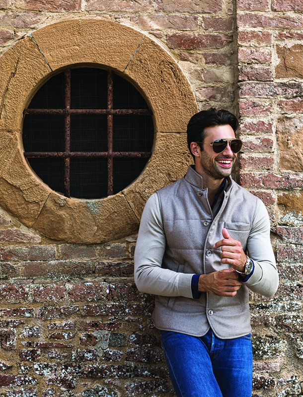 Man standing in front of brick wall of wine cellar