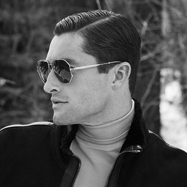 Man with dark metal frame sunglasses, turtleneck shirt and dark jacket