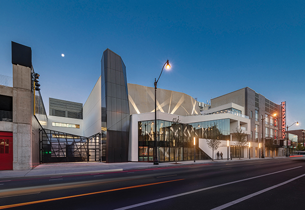 A sleek and sophisticated building with modern aesthetic. Large glass panels and dark metal cladding create a dynamic facade and design.