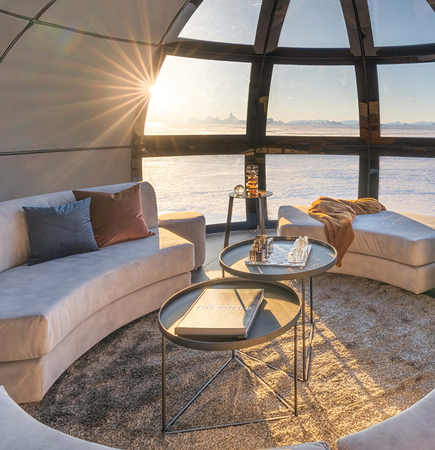 Interior of The Library, a luxurious and contemporary designed pod with floor-to-ceiling glass panels, where guests can enjoy lounging and views.