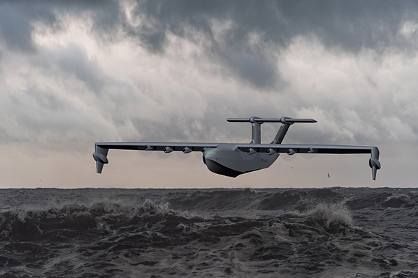 A white, four-propeller seaplane flying over a large body of water. The plane is flying low, and the waves are crashing against the shore in the background.