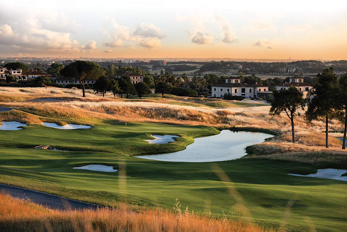 Golf course with beautiful lakes and greens. Country club in the background.