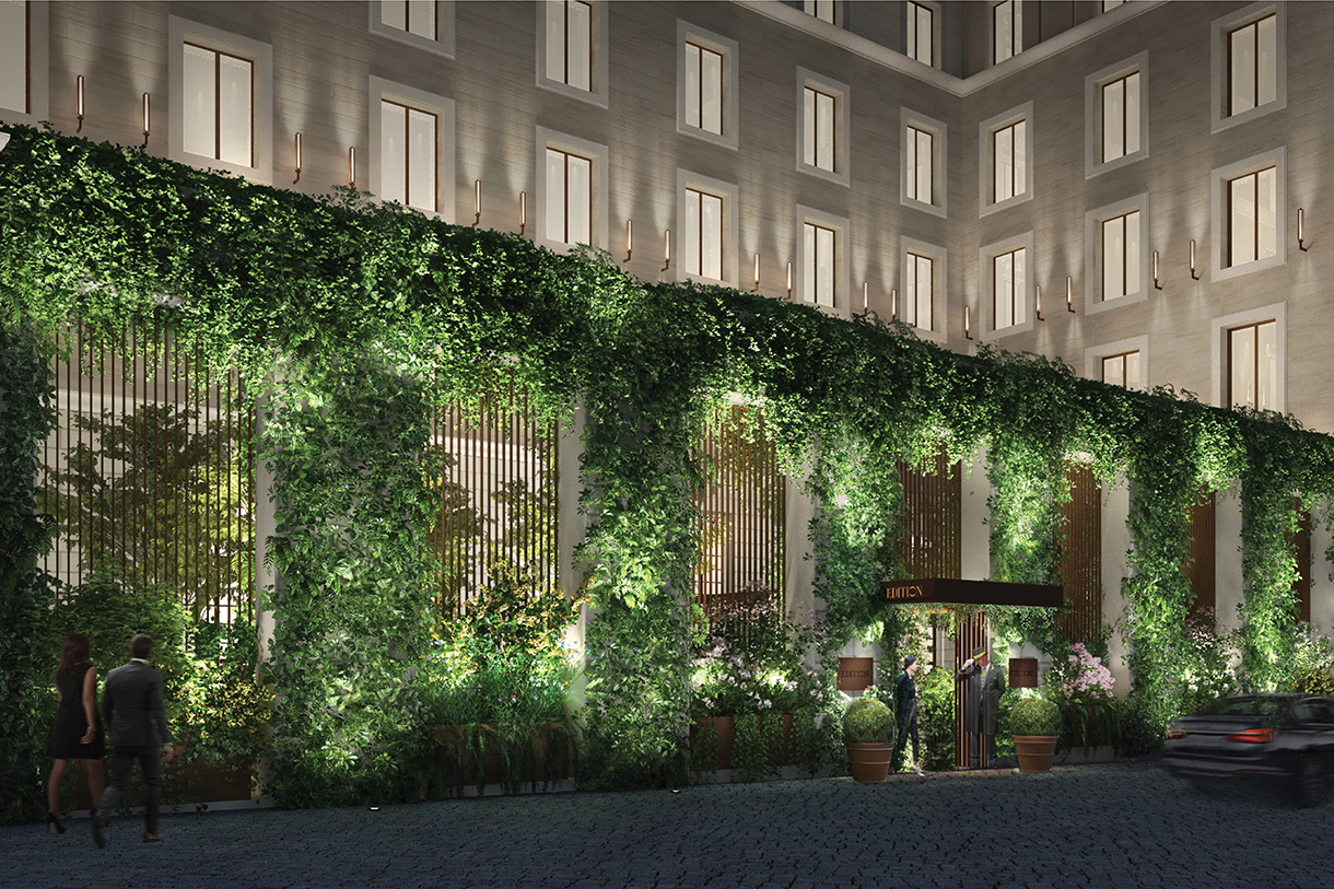 Entrance of hotel with lush greenery façade at night 