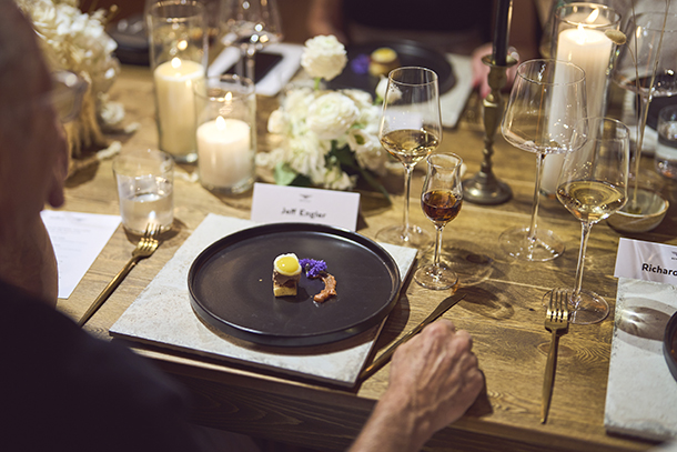 Dining at restaurant with wine, floral arrangements and and candles