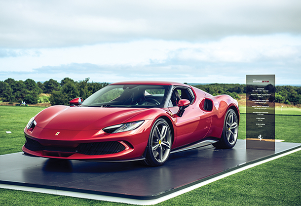 Red Ferrari on display at a car show on a golf course