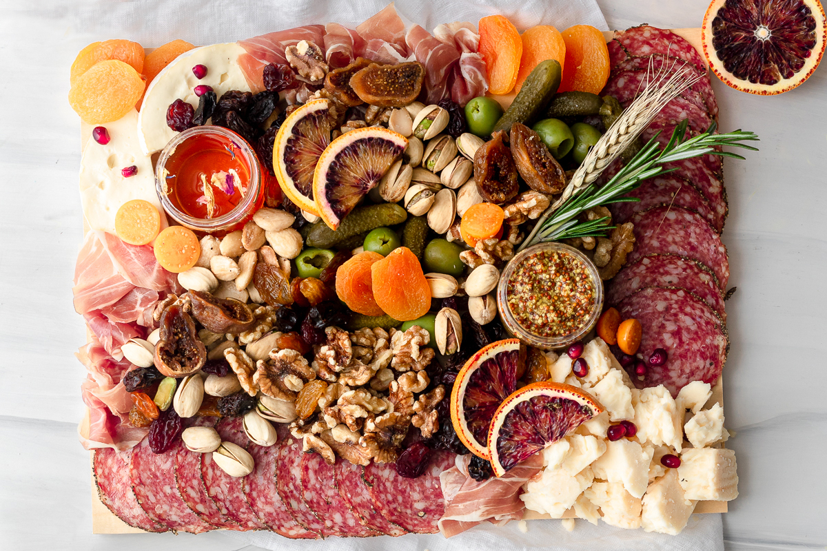 Beauty & The Board delivers all the ingredients for a luxurious grazing board, including artisanal cheeses, cured meats, olives, chocolates, dried fruits, honey, mustard, and accompaniments, all presented on a beautiful birchwood board.