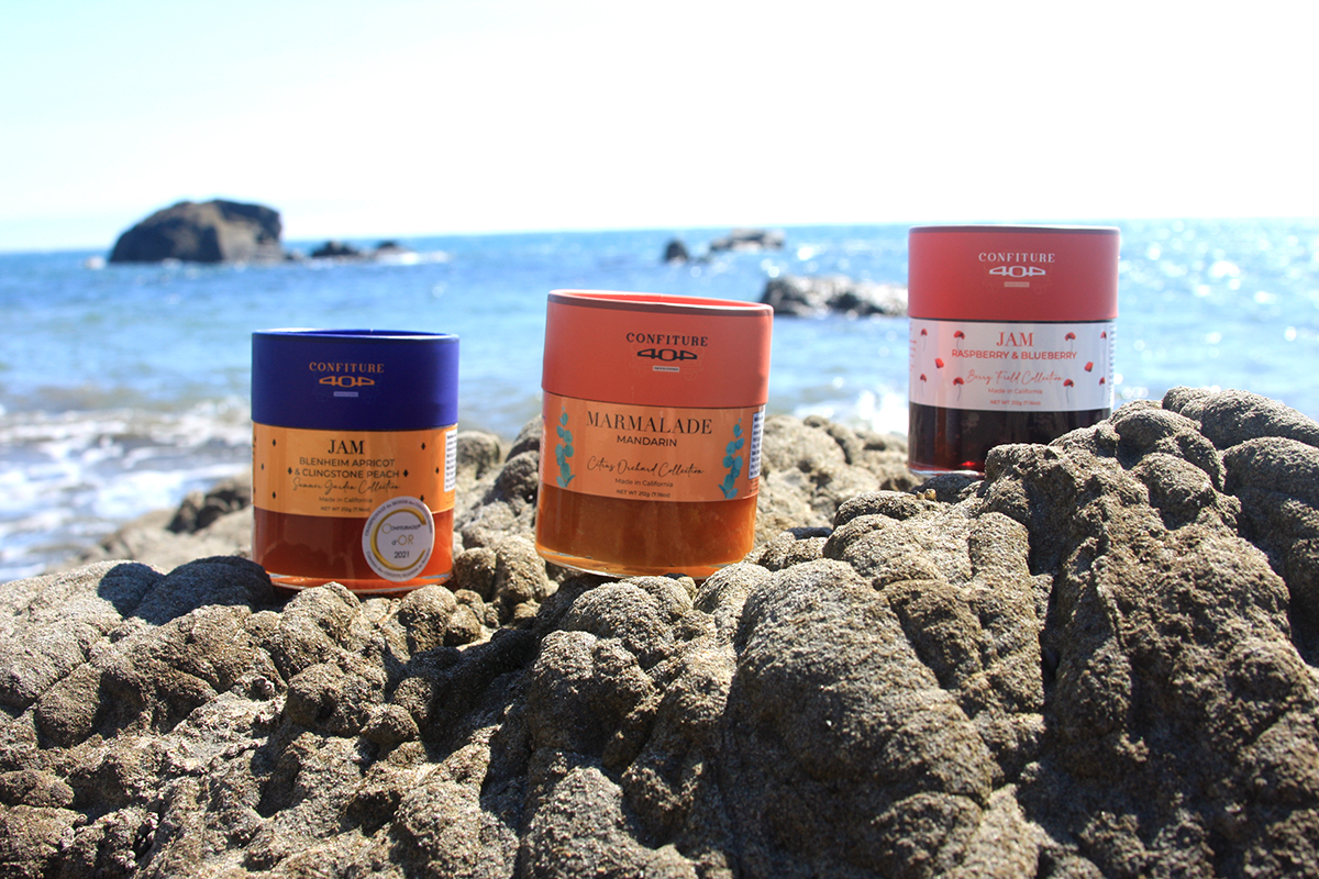 Three jars of jam on rocks by the ocean. These Field and Forest Inspired Jams are aware winning from the French owners of California-based Ladera Patisserie.