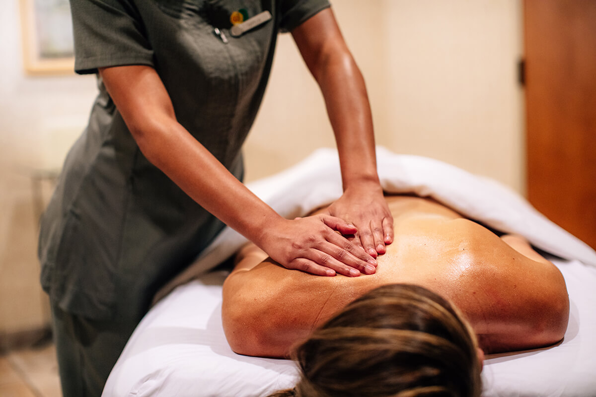 A focused view of a spa therapist giving a relaxing massage in the Four Seasons Spa Room.